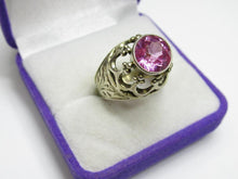 Load image into Gallery viewer, Angled view of an 875 silver amethyst ring showing the round faceted stone, bezel setting and engraved leaf shoulder.