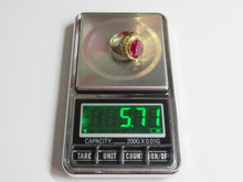 Load image into Gallery viewer, A gold ring with a round pink gemstone displayed on the scale platform of a digital pocket scale showing 5.71 grams.
