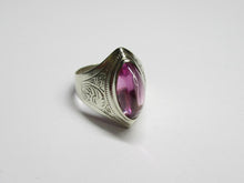 Load image into Gallery viewer, Vintage 875 silver amethyst cabochon ring on a white surface, showing the raised stone and decorative scroll engraving.