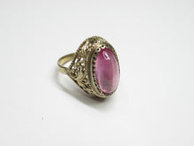 Load image into Gallery viewer, Vintage 875 silver gilt amethyst cabochon ring on a white surface, showing the slim band and ornate openwork setting.