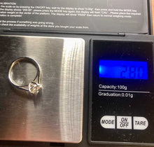 Load image into Gallery viewer, A ring scale showing a gold band ring with a clear solitaire diamond on its metal platform, with a digital display screen on the right showing a weight reading of 2.80 grams.