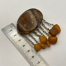 Load image into Gallery viewer, Vintage USSR Baltic Amber brooch with dangle chains, natural amber jewelry, statement piece with intricate design and gold-tone accents.
