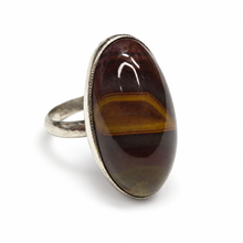 Load image into Gallery viewer, Side view of vintage Soviet 925 silver banded agate statement ring with a raised elongated oval cabochon, slim silver band, and fine decorative bezel border.
