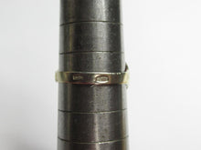 Load image into Gallery viewer, A thin gold band ring with engraved markings, shown on a dark metal ring sizer against a plain white background.

