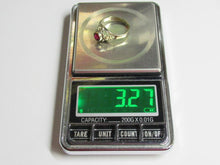 Load image into Gallery viewer, A silver ring with a red gemstone is shown on a digital scale displaying 3.27 grams.
