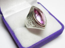 Load image into Gallery viewer, Angled view of an 875 silver amethyst cabochon ring showing the domed pink stone, bezel setting and engraved shoulder.
