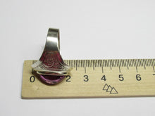 Load image into Gallery viewer, Side profile of an 875 silver amethyst cabochon ring beside a metric ruler, showing the domed stone and wide shoulder.
