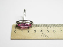 Load image into Gallery viewer, Side profile of an 875 silver oval amethyst ring beside a metric ruler, showing the elongated frame and gemstone setting.
