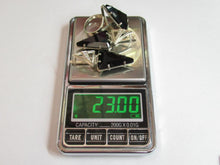 Load image into Gallery viewer, A stack of silver rings with black stones and clear crystal accents sits on a digital scale displaying 23.00g.
