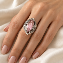 Load image into Gallery viewer, Vintage 875 silver pink amethyst cabochon ring worn on a finger, showing its elongated shape and engraved silver frame.
